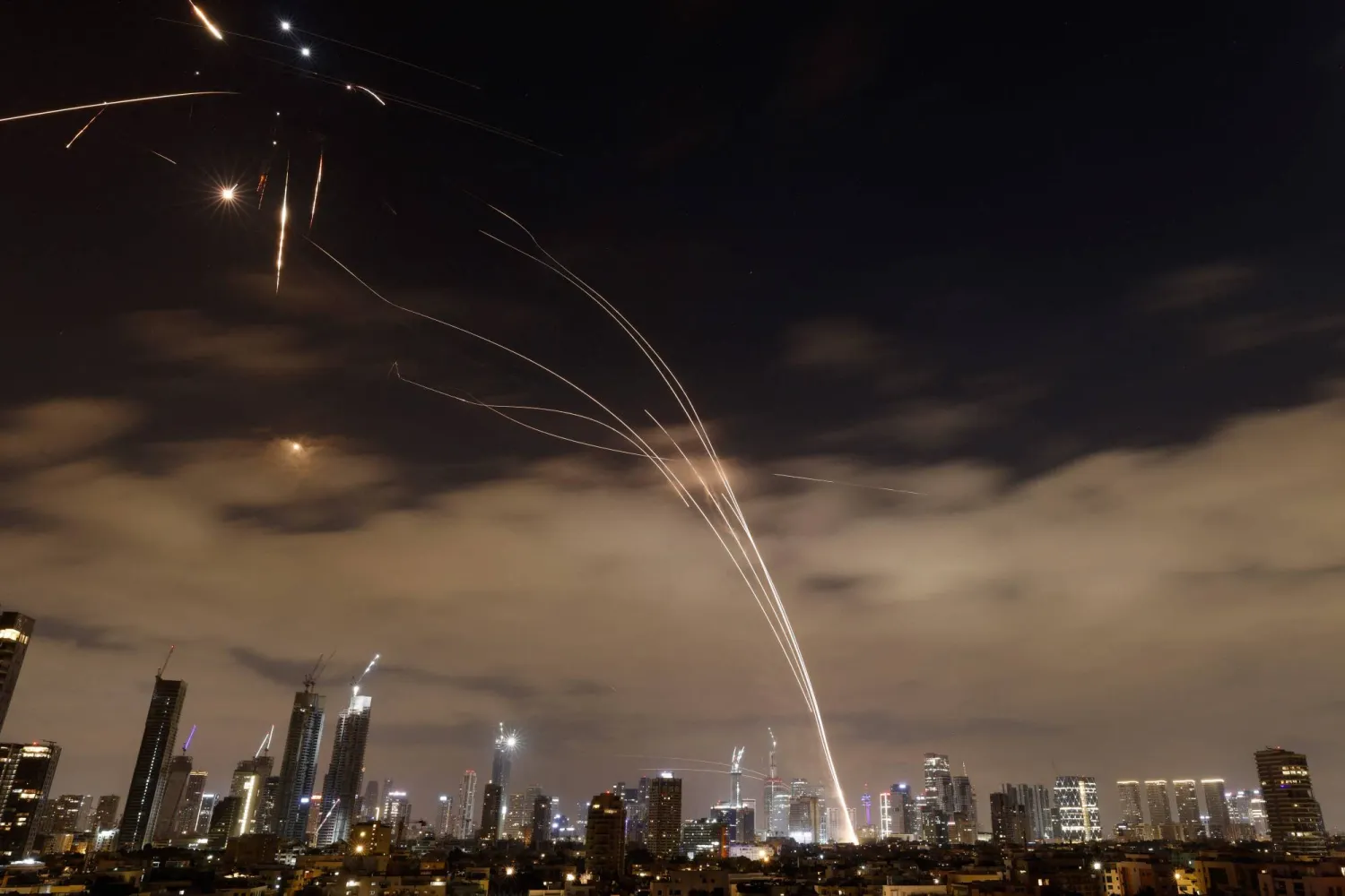 إطلاق صواريخ والدفاعات الإسرائيلية خلال تصديها لها فوق تل أبيب (أ.ف.ب)