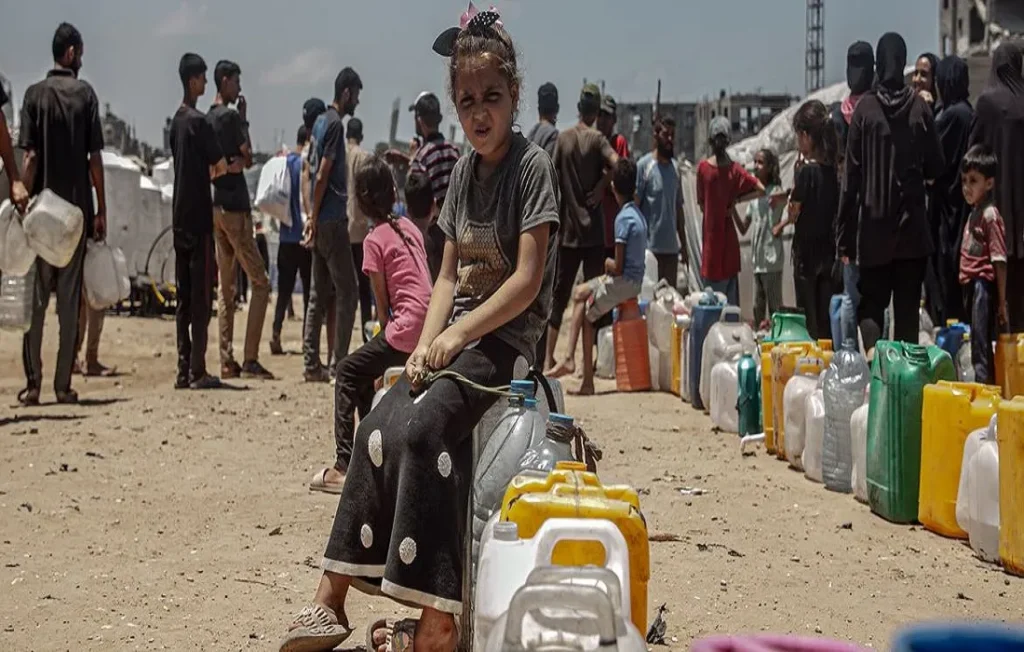 منظمة الصحة العالمية وتقرير حول الفقر المائي – والصورة من الأمم المتحدة لطفلة تنتظر دورها في الحصول على المياه