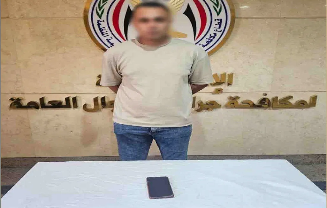 المتهم وأمامه المحمول الذي استخدمه في الواقعة