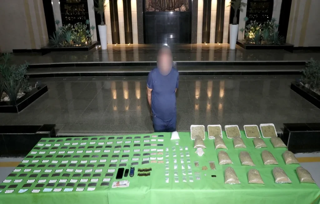 أحد أفراد التشكيل وجانب من المضبوطات