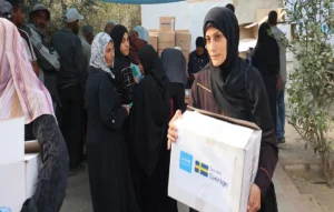 المساعدات الإنسانية في غزة – وفي الصورة سيدة من القطاع تحصل على بعض المعونات الغذائية (الصورة من الأمم المتحدة)