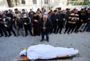 أحد الفلسطينيين وهو يصلى عليه بعد استشهاده في غارات جوية إسرائيلية بغزة