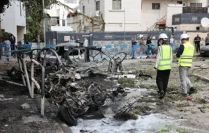 خدمة الطوارئ في إسرائيل يعاينان سيارات محترقة جراء اعتراض صواريخ باليستية من إيران في تل أبيب السبت(إ.ب.أ)