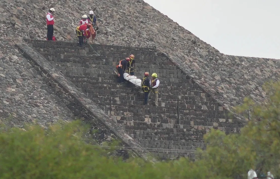 أهرامات المكسيك التي شهدت الحادثة وعاملي الإنقاذ يحملون أحد الضحايا